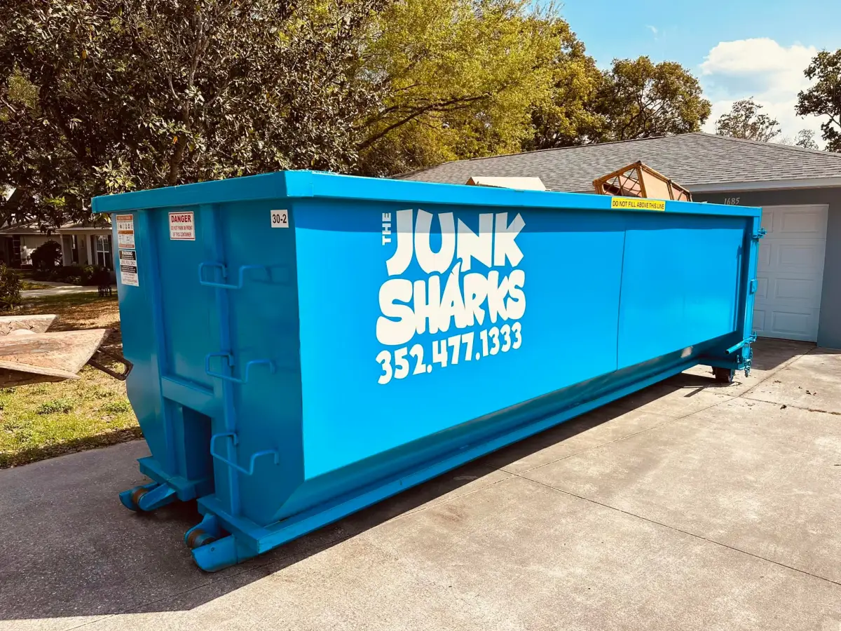 A Junk Sharks roll-off dumpster set on the driveway of an Ocala home